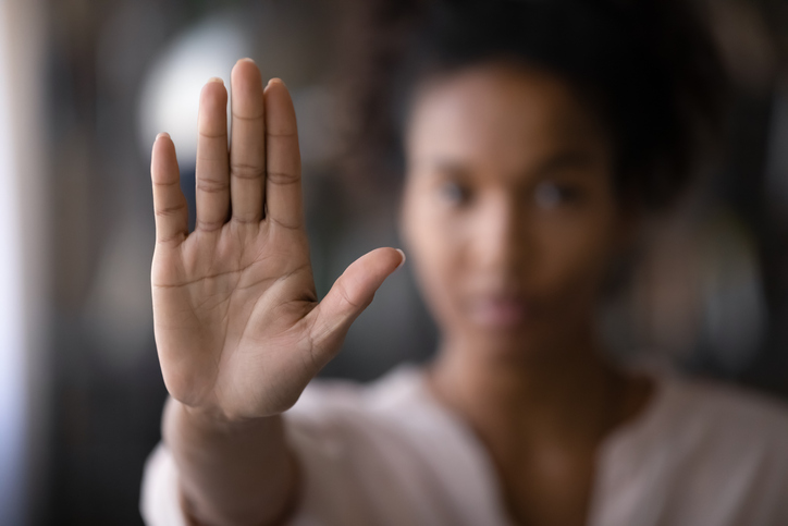 Crop close up focus of African American woman show palm hand against racial gender discrimination. Determined mixed race female make sign gesture protest against domestic violence or abortion.