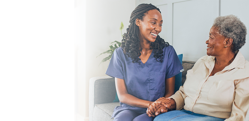 Black woman doctor smiling with older hispanic patient