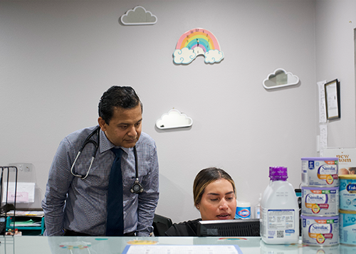 Dr. Sushil Anand interacts with a member of his team inside Sunshine Pediatrics of Upland on April 29.