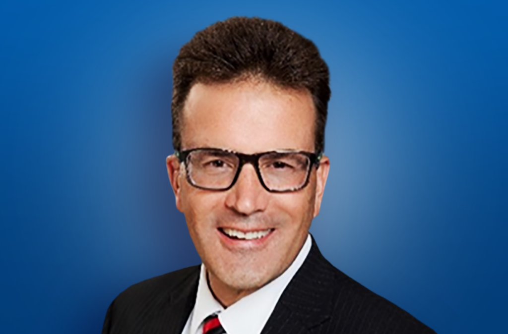 Dr Daniel headshot with blue background