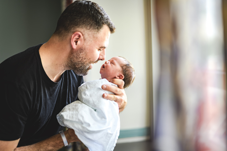 A New born baby boy resting in father arms
