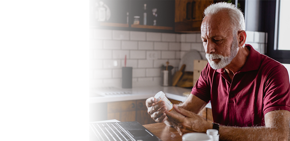 white man looking at prescription bottle