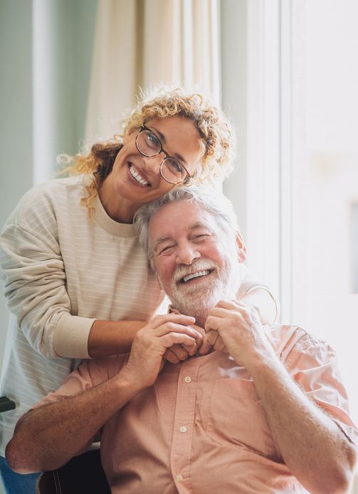 Senior man smiles warmly as his daughter tenderly embraces him. The scene captures tenderness, affection, and emotional connection, symbolizing affection, care, and companionship in adulthood.