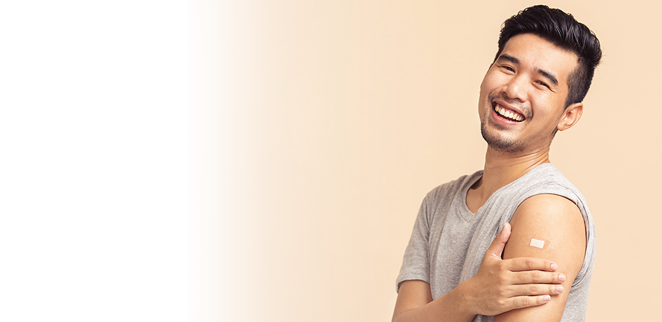 Young asian man showing vaccine bandaid